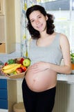 Junge schöne schwangere Frau, die einen Korb von Früchten hält stockbilder Junge schöne schwangere Frau, die einen Korb von Früchten hält stockbilder