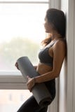 Junge sportliche Frau, die Eignungsmatte, Yogalehrer hält lizenzfreie stockbilder Junge sportliche Frau, die Eignungsmatte, Yogalehrer hält lizenzfreie stockbilder