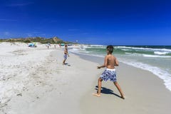 Jungen, die Tennis auf dem Strand spielen lizenzfreie stockfotos Jungen, die Tennis auf dem Strand spielen lizenzfreie stockfotos