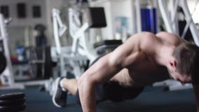 Junger athletischer Mann, den das Handeln drückt, ups in eine Turnhalle mit dem nackten Torso stock video Junger athletischer Mann, den das Handeln drückt, ups in eine Turnhalle mit dem nackten Torso stock video