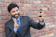 Junger Geschäftsmann, der ein selfie mit seinem Smartphone nimmt lizenzfreie stockfotos Junger Geschäftsmann, der ein selfie mit seinem Smartphone nimmt lizenzfreie stockfotos
