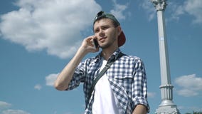 Junger gutaussehender Mann, der am Telefon spricht stock footage Junger gutaussehender Mann, der am Telefon spricht stock footage