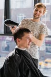 Junger Hippie-Kerl im Friseursalon, Friseur, der Haar mit den Scheren, blow-drying schneidet Konzeptmannplatz stockfotos Junger Hippie-Kerl im Friseursalon, Friseur, der Haar mit den Scheren, blow-drying schneidet Konzeptmannplatz stockfotos