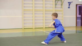 Junger kaukasischer Junge im nationalen chinesischen Kleid übt südliche Faustübungen Kung Fu-wushu tai-Chiform Nanquan stock footage Junger kaukasischer Junge im nationalen chinesischen Kleid übt südliche Faustübungen Kung Fu-wushu tai-Chiform Nanquan stock footage