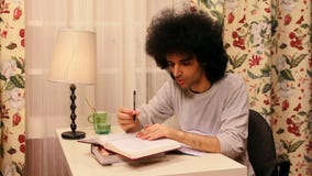 junger Mann, der auf dem Buch studiert stock footage junger Mann, der auf dem Buch studiert stock footage
