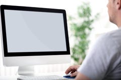 Junger Mann, der an Computer arbeitet lizenzfreie stockfotografie Junger Mann, der an Computer arbeitet lizenzfreie stockfotografie
