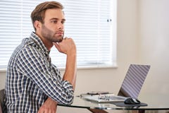 Junger Mann, der durchdacht den Abstand, seine Arbeit zögernd untersucht stockbild Junger Mann, der durchdacht den Abstand, seine Arbeit zögernd untersucht stockbild