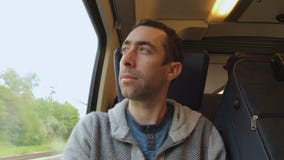 Junger Mann, der heraus auf einen Zug und Blicke das Fenster reist Junger Mann, der heraus auf einen Zug und Blicke das Fenster reist
