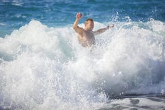 Junger Mann, der in stürmendem Meer badet lizenzfreies stockfoto Junger Mann, der in stürmendem Meer badet lizenzfreies stockfoto