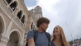 Junger Mann und Frau, die um Sultan Abdul Samad Building in Kuala Lumpur-vity, Malaysia geht stock video footage Junger Mann und Frau, die um Sultan Abdul Samad Building in Kuala Lumpur-vity, Malaysia geht stock video footage