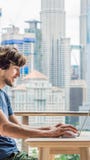 Junger Mann unterrichtet eine Fremdsprache oder lernt eine Fremdsprache im Internet auf ihrem Balkon gegen den Hintergrund von lizenzfreie stockfotografie Junger Mann unterrichtet eine Fremdsprache oder lernt eine Fremdsprache im Internet auf ihrem Balkon gegen den Hintergrund von lizenzfreie stockfotografie