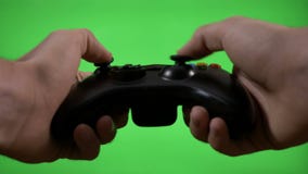 Junger Spielspieler übergibt die Kontrollesteuerknüppelschlüssel, die Videospiel auf grünem Schirm spielen - stock video footage Junger Spielspieler übergibt die Kontrollesteuerknüppelschlüssel, die Videospiel auf grünem Schirm spielen - stock video footage