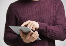 Junger weißer Mann, der einen Tablet-Computer, mittleren Abschnitt verwendet lizenzfreies stockbild Junger weißer Mann, der einen Tablet-Computer, mittleren Abschnitt verwendet lizenzfreies stockbild