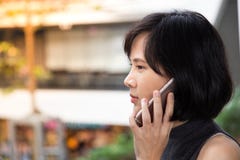 Junges asiatisches Mädchen, das intelligentes Telefon im Mall verwendet stockfotos Junges asiatisches Mädchen, das intelligentes Telefon im Mall verwendet stockfotos