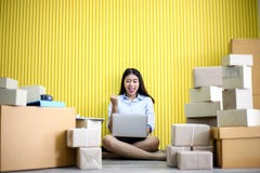 Junges asiatisches Mädchen ist Freiberufler Startung Kleinunternehmerschreibensadresse auf Pappschachtel am Arbeitsplatz und vers lizenzfreies stockbild Junges asiatisches Mädchen ist Freiberufler Startung Kleinunternehmerschreibensadresse auf Pappschachtel am Arbeitsplatz und vers lizenzfreies stockbild