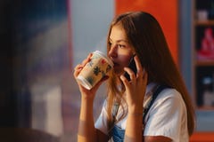 Junges attraktives hübsches Mädchen am Café mit Kaffee und Telefon an MO stockfotos Junges attraktives hübsches Mädchen am Café mit Kaffee und Telefon an MO stockfotos