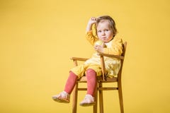 Junges Baby im gelben Kleid auf gelbem Hintergrund stockfotos Junges Baby im gelben Kleid auf gelbem Hintergrund stockfotos