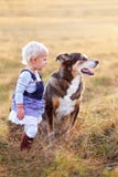 Junges Kleinkind-Mädchen, das mit ihrem Pat Dog Outside an einem Fall-Tag spricht stockbild Junges Kleinkind-Mädchen, das mit ihrem Pat Dog Outside an einem Fall-Tag spricht stockbild