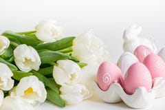 Junges Küken in Wanne, 2 malte Eier und Blumen Weiße Tulpen, bunte Eier auf Weiß lizenzfreie stockfotos Junges Küken in Wanne, 2 malte Eier und Blumen Weiße Tulpen, bunte Eier auf Weiß lizenzfreie stockfotos