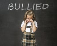 Junior schoolgirl crying victim of bullying suffering stress and fear at school Stock Photos Junior schoolgirl crying victim of bullying suffering stress and fear at school Stock Photos