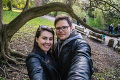 Junte tomar el selfie en parque debajo del árbol imagenes de archivo Junte tomar el selfie en parque debajo del árbol imagenes de archivo