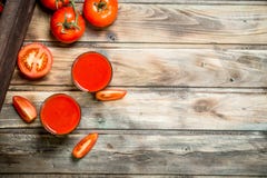 Jus de tomates dans des tranches en verre et de tomate image stock Jus de tomates dans des tranches en verre et de tomate image stock