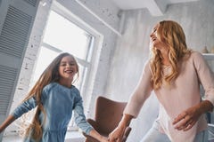 Juste danse ! Mère et fille tenant des mains et souriant tandis que image libre de droits Juste danse ! Mère et fille tenant des mains et souriant tandis que image libre de droits