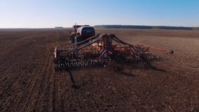 4k aerial footage of a modern tractor plowing dry field, preparing land for sowing