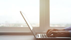 4K. hands typing on laptop computer keyboard, pan camera. business woman working on laptop notebook in work space with window view stock footage 4K. hands typing on laptop computer keyboard, pan camera. business woman working on laptop notebook in work space with window view stock footage
