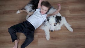4k. Happy little boy lying on australian shepherd merle dog