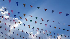4K langzame motie van de kleurrijke driehoekige eerlijke vlaggen die van de ontwerpdecoratie op de wind blazen die op blauwe heme stock videobeelden 4K langzame motie van de kleurrijke driehoekige eerlijke vlaggen die van de ontwerpdecoratie op de wind blazen die op blauwe heme stock videobeelden