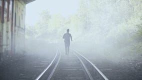 4K mens die snel op mistige treinsporen weglopen Achter mening Abstract schot als achtergrond Het creatieve schot van de levensst stock footage 4K mens die snel op mistige treinsporen weglopen Achter mening Abstract schot als achtergrond Het creatieve schot van de levensst stock footage