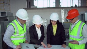 4k Ufny żeński inżynier lub architekt dyskutuje budów zagadnienia z męskimi kolegami zieleni kamizelki zdjęcie wideo 4k Ufny żeński inżynier lub architekt dyskutuje budów zagadnienia z męskimi kolegami zieleni kamizelki zdjęcie wideo
