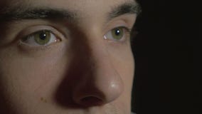 4k UHD - Close-up of a young man eyes in the dark watching TV stock footage 4k UHD - Close-up of a young man eyes in the dark watching TV stock footage