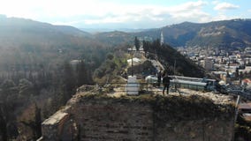 4k εναέρια άποψη της κορυφής του φρουρίου, του σταυρού και των τουριστών Narikala στην αιχμή απόθεμα βίντεο 4k εναέρια άποψη της κορυφής του φρουρίου, του σταυρού και των τουριστών Narikala στην αιχμή απόθεμα βίντεο