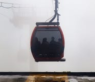Kabelwagenhoogtepunt van Toeristen die naar Bestemming gaan Ropeway Cabine in Sterk Mistmilieu stock afbeelding Kabelwagenhoogtepunt van Toeristen die naar Bestemming gaan Ropeway Cabine in Sterk Mistmilieu stock afbeelding