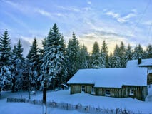 Kabinen i den djupfrysta snöskogen framme av julgranar, royaltyfri fotografi Kabinen i den djupfrysta snöskogen framme av julgranar, royaltyfri fotografi