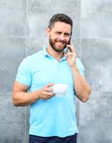 Kaffe för anledningsentreprenördrink Mandrinkcappuccino talar grå väggbakgrund för telefonen Om även du dricker på kaffe arkivbilder Kaffe för anledningsentreprenördrink Mandrinkcappuccino talar grå väggbakgrund för telefonen Om även du dricker på kaffe arkivbilder