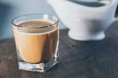 Kaffe i en bakgrund för exponeringsglaswhitblått arkivfoto Kaffe i en bakgrund för exponeringsglaswhitblått arkivfoto