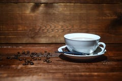 Kaffe i en vit kopp på en mörk träbakgrund med kaffebönor fotografering för bildbyråer Kaffe i en vit kopp på en mörk träbakgrund med kaffebönor fotografering för bildbyråer