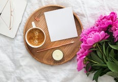 Kaffee, rosa Pfingstrosen und leeres Papier auf dem Bett stockbilder Kaffee, rosa Pfingstrosen und leeres Papier auf dem Bett stockbilder