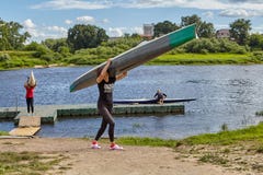 Kajak que lleva de la deportista de dos muchachas en el hombro, Polotsk, Belar Imagen de archivo libre de regalías Kajak que lleva de la deportista de dos muchachas en el hombro, Polotsk, Belar Imagen de archivo libre de regalías