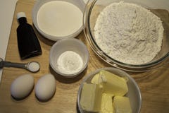Kakaingredienser i bunkar på träbakgrund arkivbilder Kakaingredienser i bunkar på träbakgrund arkivbilder