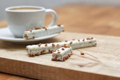 Kakarån i glasyr och kopp kaffe på en trätabell fotografering för bildbyråer Kakarån i glasyr och kopp kaffe på en trätabell fotografering för bildbyråer
