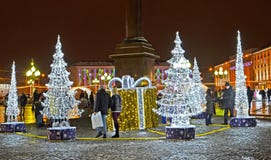 Kaliningrad, Rosja Ludzie chodzą wśród olśniewających jedlin w zima wieczór Zwycięstwo kwadrat obrazy royalty free Kaliningrad, Rosja Ludzie chodzą wśród olśniewających jedlin w zima wieczór Zwycięstwo kwadrat obrazy royalty free