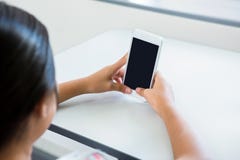 Kantjusterad bild av flickan som använder mobiltelefonen royaltyfri fotografi Kantjusterad bild av flickan som använder mobiltelefonen royaltyfri fotografi