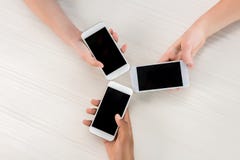 kantjusterat skott av tonåringar som rymmer smartphones med tomma skärmar arkivfoto kantjusterat skott av tonåringar som rymmer smartphones med tomma skärmar arkivfoto