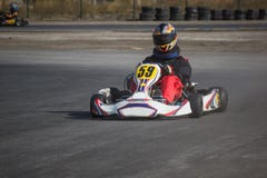Karting - conducteur dans le casque sur le circuit de kart photographie stock Karting - conducteur dans le casque sur le circuit de kart photographie stock