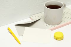 Kartka z pozdrowieniami na białym tle z notatkami, kopertą, piórem, macaron i filiżanką herbata, obraz stock Kartka z pozdrowieniami na białym tle z notatkami, kopertą, piórem, macaron i filiżanką herbata, obraz stock