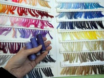 Katalog mit Proben von Faden und von drei Spulen in der Hand lizenzfreies stockbild Katalog mit Proben von Faden und von drei Spulen in der Hand lizenzfreies stockbild